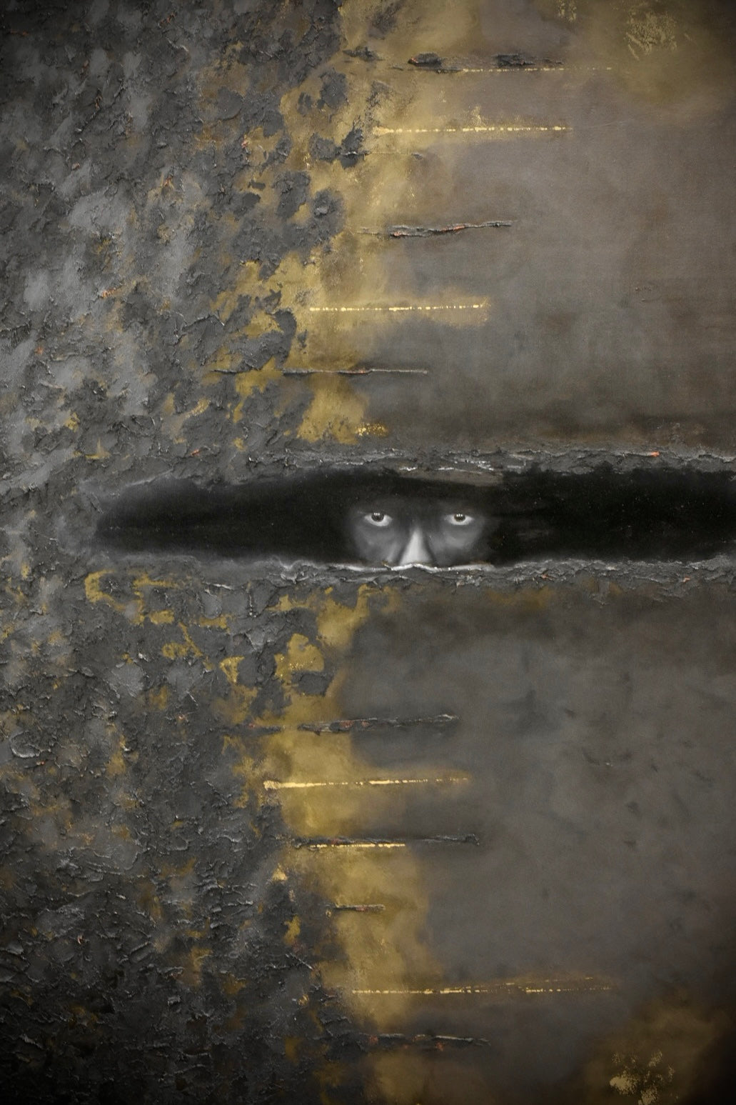 Abstract textured artwork featuring a dark horizontal band with a pair of pale eyes looking forward, set against a mottled gray and gold background with distressed metallic-looking textures.