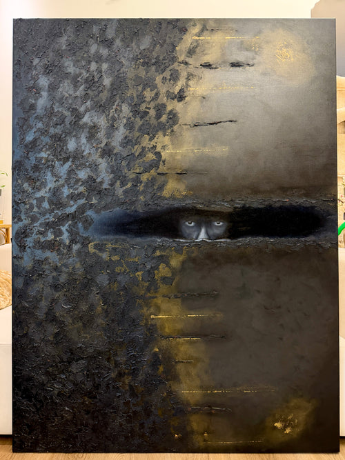 A large textured painting or canvas print featuring a dark, moody scene with a horizontal slit of light revealing a pair of glowing eyes. The artwork has a split color identity with dark charcoal and black on the left, and warm gold and brown tones on the right.