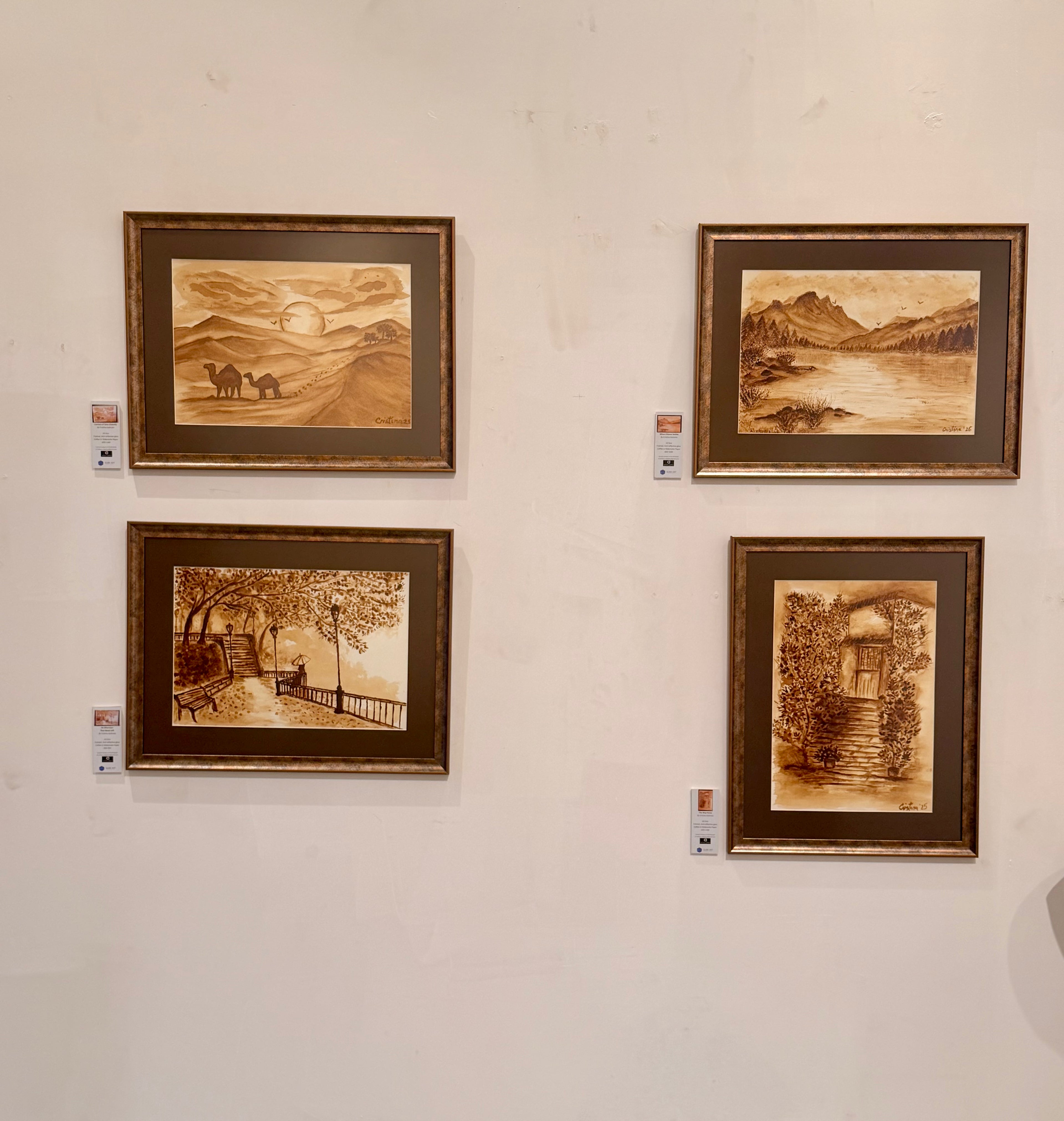 Gallery installation view featuring Where Silence Settles and three other original coffee paintings on watercolour paper by Cristina Gabriela, exhibited in Dubai 2026